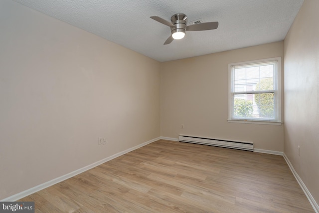 unfurnished room with baseboards, baseboard heating, light wood-style flooring, and a textured ceiling