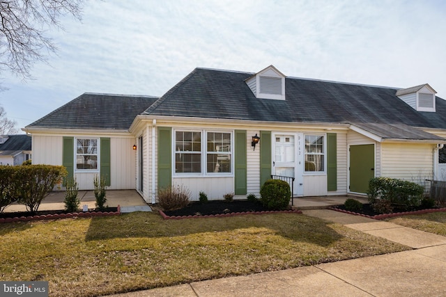 cape cod-style house with board and batten siding, a porch, and a front yard