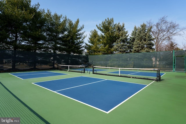 view of tennis court featuring community basketball court and fence