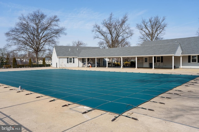 pool with a patio and fence