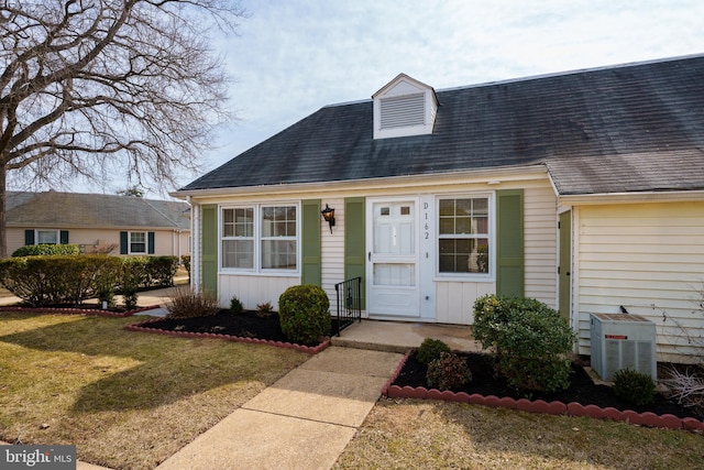 new england style home with a front yard and board and batten siding