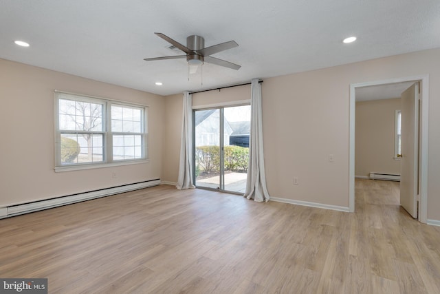 spare room with recessed lighting, baseboard heating, and light wood-style flooring