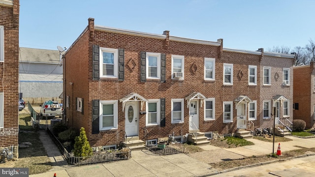 townhome / multi-family property featuring brick siding and entry steps