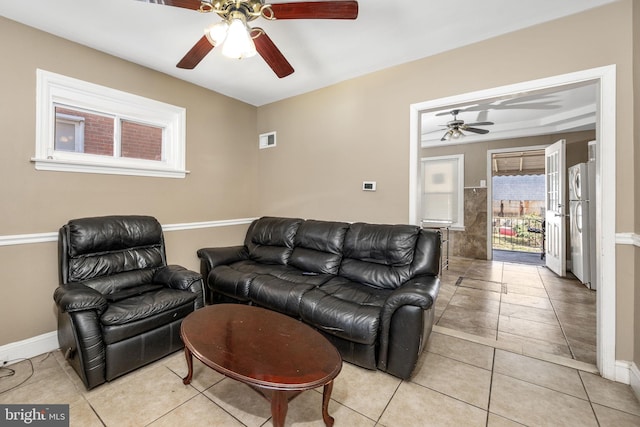 living area featuring a ceiling fan, light tile patterned floors, baseboards, and visible vents