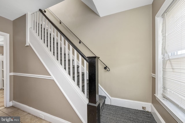 stairs with tile patterned floors and baseboards