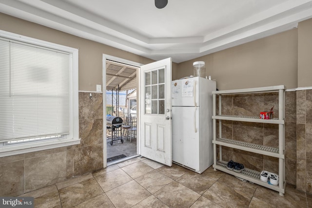 kitchen with tile walls and freestanding refrigerator