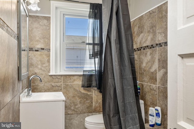 full bath with toilet, curtained shower, tile walls, crown molding, and vanity