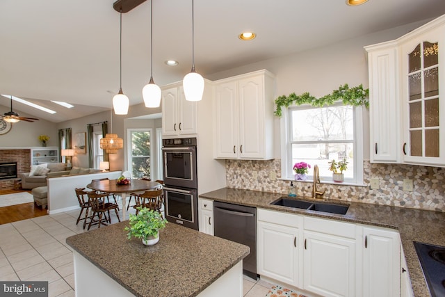 kitchen featuring double wall oven, a sink, glass insert cabinets, backsplash, and dishwashing machine