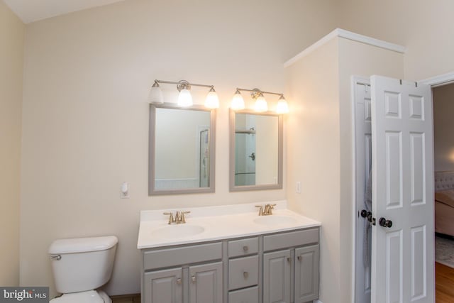 ensuite bathroom with double vanity, toilet, ensuite bathroom, and a sink