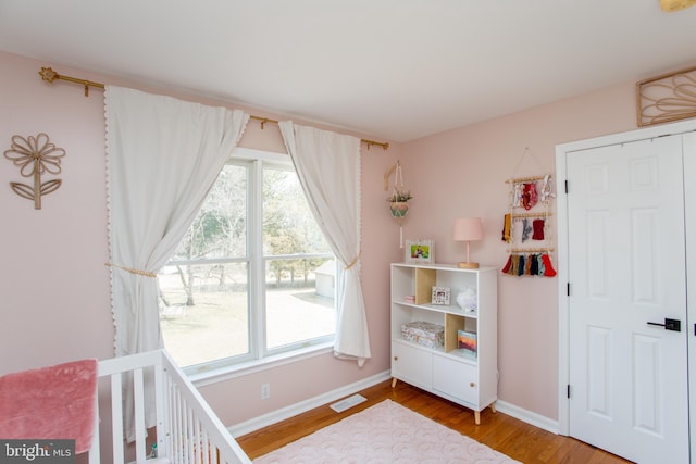 bedroom featuring visible vents, baseboards, and wood finished floors