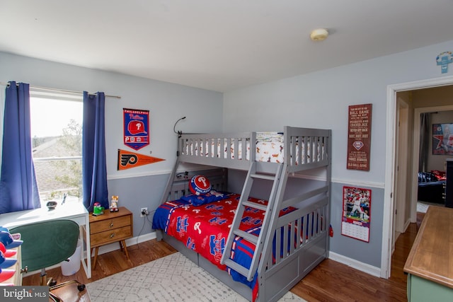 bedroom with baseboards and wood finished floors