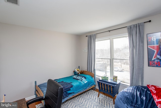 bedroom with visible vents and wood finished floors