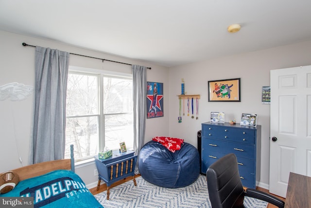 bedroom featuring multiple windows, light wood-style floors, and baseboards