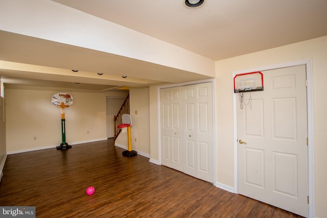 finished below grade area with stairway, baseboards, and dark wood-style floors