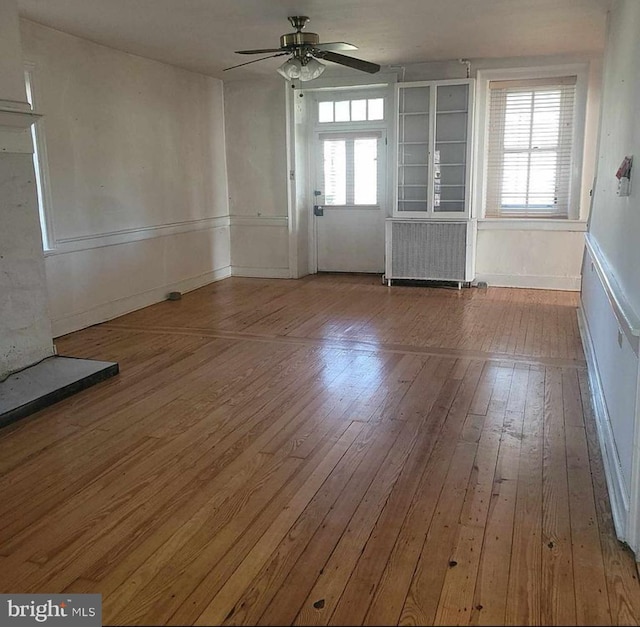 spare room featuring ceiling fan, radiator, and hardwood / wood-style floors