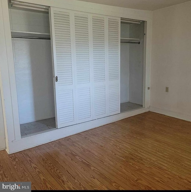 unfurnished bedroom featuring wood finished floors and a closet