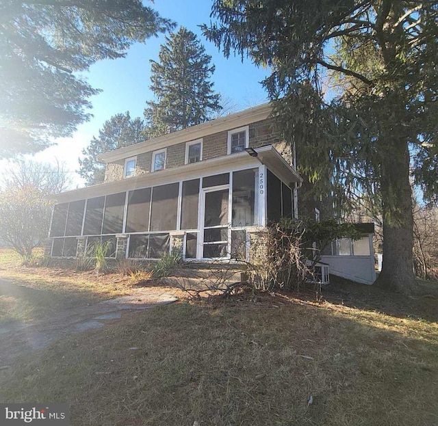 rear view of house featuring a sunroom