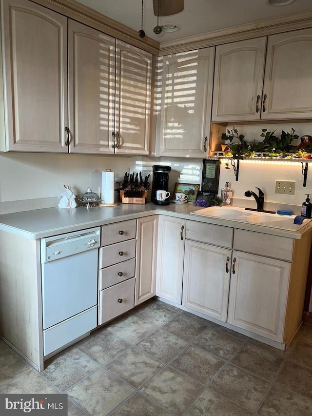 kitchen featuring dishwasher, light countertops, and a sink