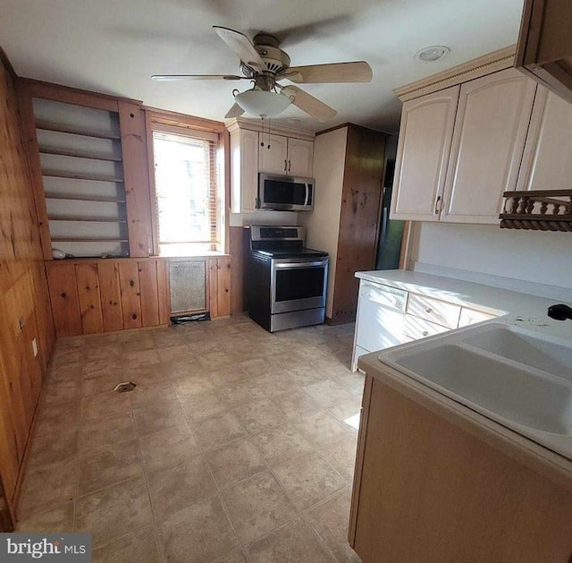 kitchen featuring a sink, appliances with stainless steel finishes, a ceiling fan, and light countertops