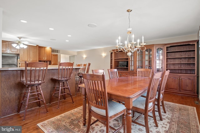 dining space with ceiling fan with notable chandelier, recessed lighting, visible vents, and light wood finished floors