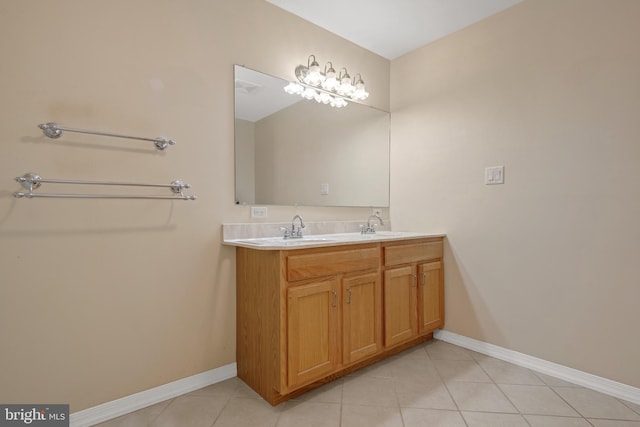 bathroom featuring tile patterned flooring, a sink, baseboards, and double vanity