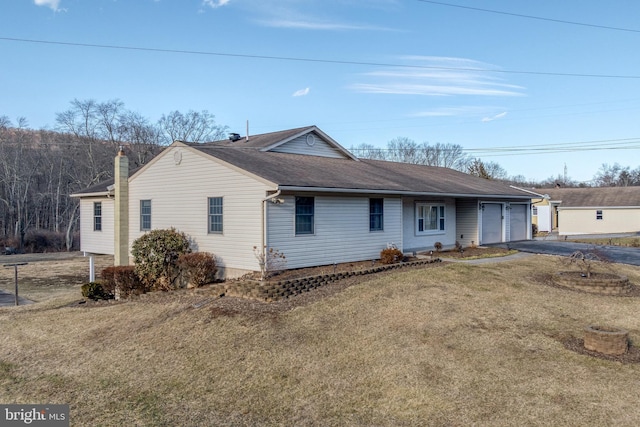 ranch-style house featuring a front lawn, an attached garage, driveway, and roof with shingles