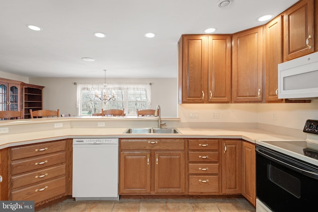 kitchen featuring recessed lighting, brown cabinets, an inviting chandelier, white appliances, and a sink