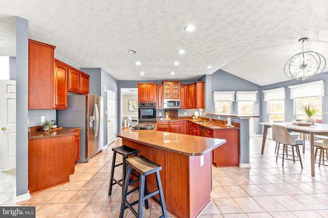 kitchen featuring a sink, stainless steel appliances, a peninsula, a breakfast bar area, and light tile patterned floors
