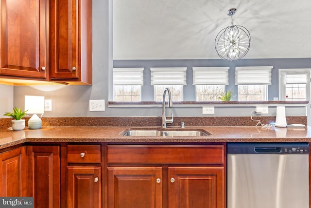 kitchen with dark countertops, dishwasher, brown cabinetry, and a sink