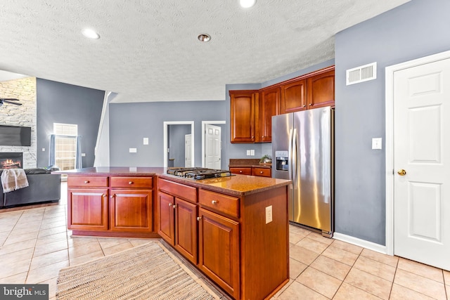 kitchen featuring light tile patterned floors, visible vents, appliances with stainless steel finishes, and a center island