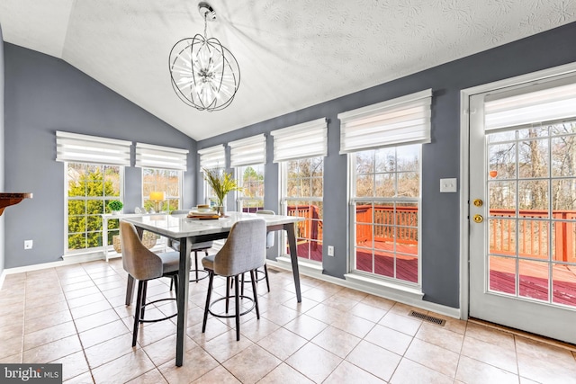 tiled dining room with an inviting chandelier, plenty of natural light, visible vents, and lofted ceiling