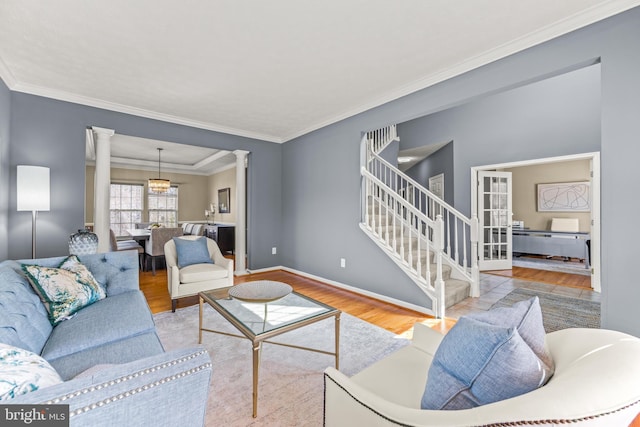 living room with ornamental molding, decorative columns, baseboards, and wood finished floors