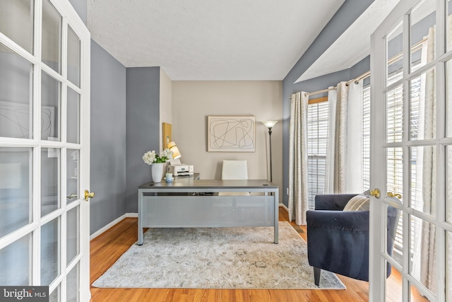 office area featuring french doors, baseboards, a textured ceiling, and wood finished floors