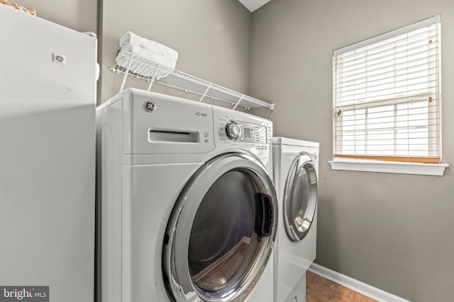 clothes washing area featuring washer and dryer, laundry area, and baseboards