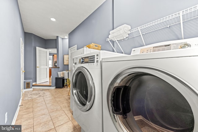 laundry room with washer and dryer, laundry area, light tile patterned flooring, and baseboards