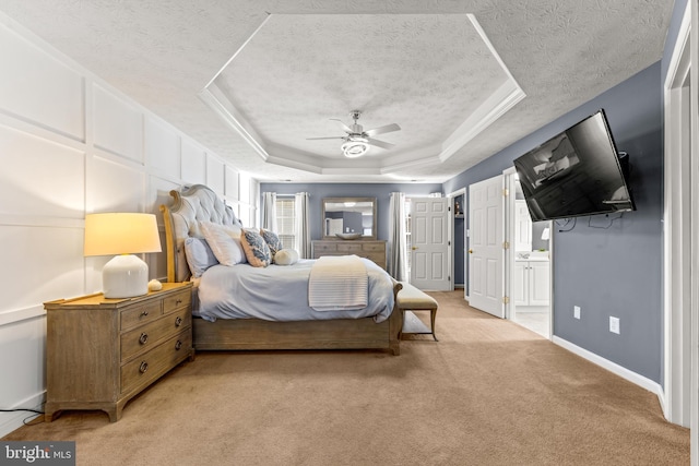bedroom featuring a tray ceiling, light colored carpet, baseboards, and a textured ceiling