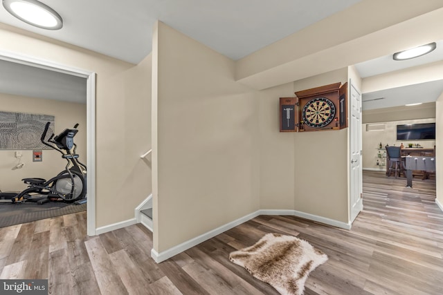 hall featuring baseboards and wood finished floors