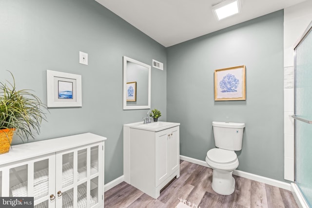 full bath with visible vents, an enclosed shower, toilet, wood finished floors, and baseboards