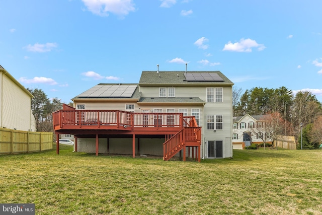 rear view of house featuring stairway, a wooden deck, a yard, and fence