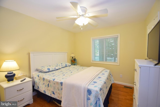 bedroom featuring visible vents, baseboards, dark wood-style floors, and a ceiling fan