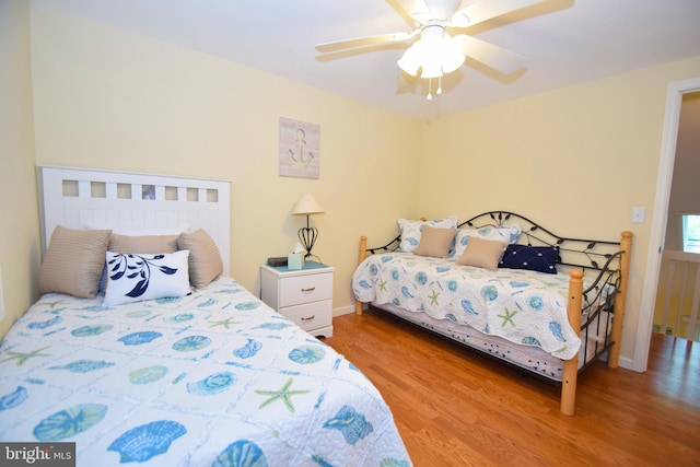 bedroom with a ceiling fan, light wood-style floors, and baseboards