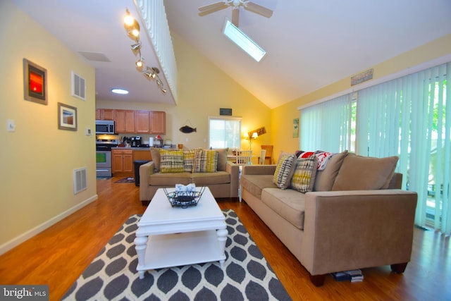 living room with a skylight, light wood-style floors, and visible vents