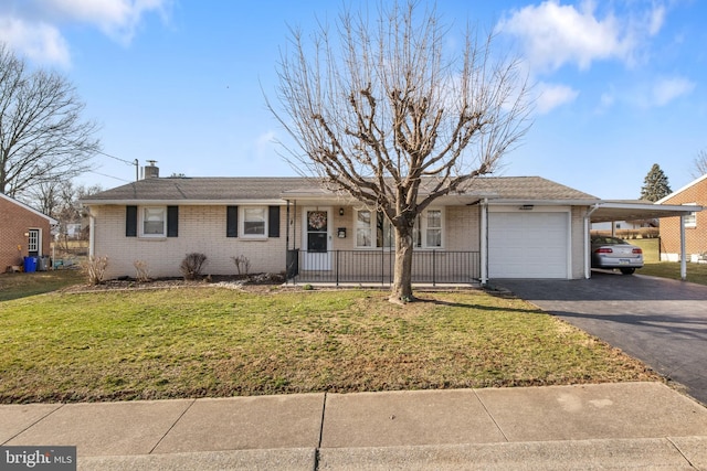 ranch-style home with an attached carport, a front yard, a garage, aphalt driveway, and brick siding