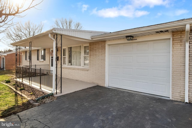 view of front of house with an attached garage, covered porch, brick siding, and driveway