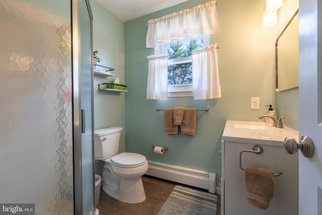 bathroom featuring a baseboard heating unit, toilet, wood finished floors, and vanity