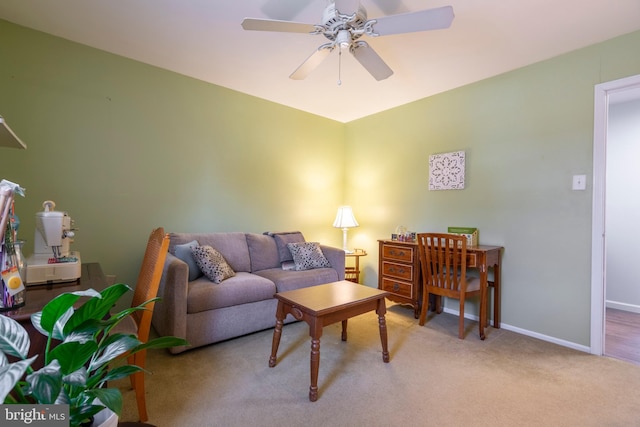 carpeted living area with a ceiling fan and baseboards