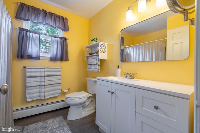 bathroom featuring a baseboard heating unit, toilet, wood finished floors, and vanity