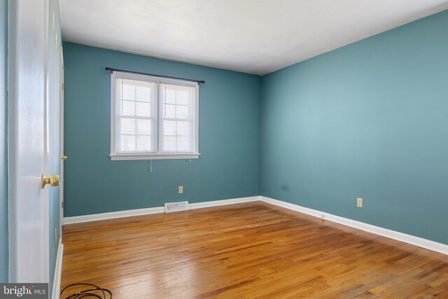 spare room featuring visible vents, light wood-type flooring, and baseboards