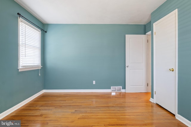 unfurnished bedroom featuring visible vents, baseboards, and wood finished floors