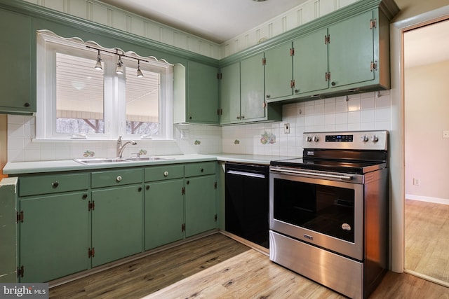 kitchen featuring tasteful backsplash, black dishwasher, light wood-style flooring, electric stove, and a sink